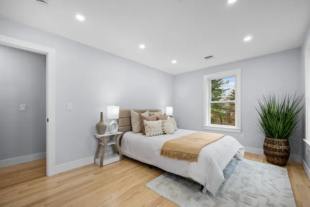 a bedroom with a large bed and a potted plant