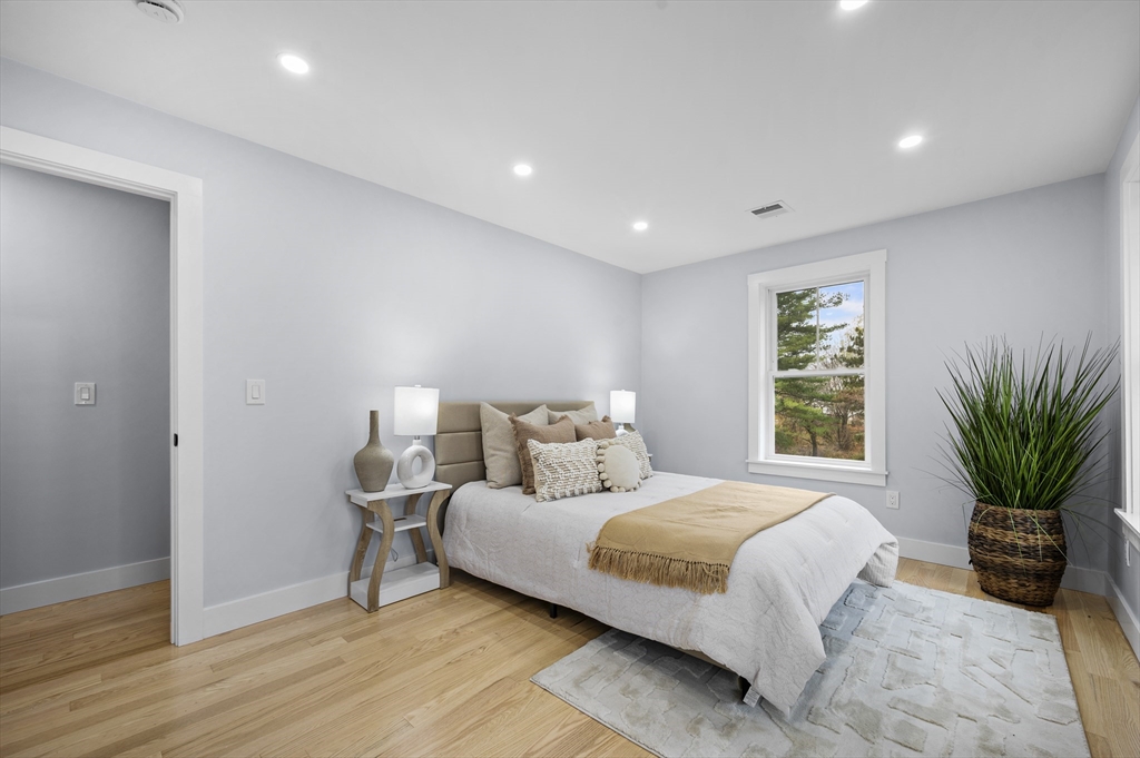 69 Readville Street, Unit B Boston, MA 02136 - Photo 17 of 38 a bedroom with a large bed and a potted plant