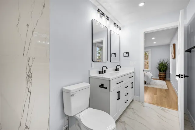 a spacious bathroom with a toilet sink and mirror