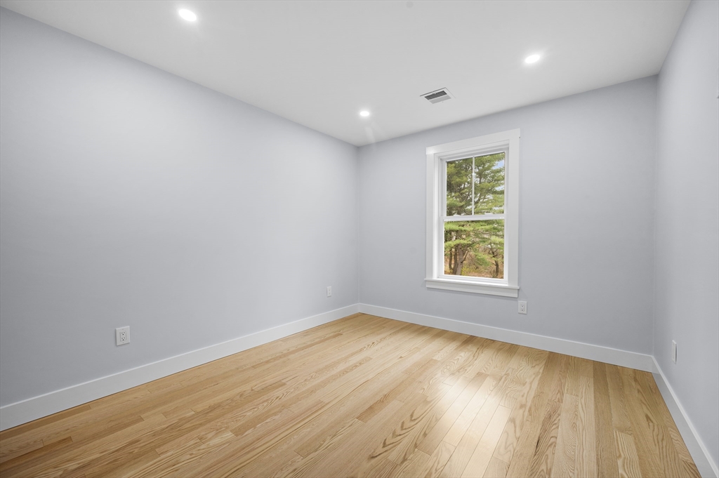 69 Readville Street, Unit B Boston, MA 02136 - Photo 23 of 38 an empty room with wooden floor and windows
