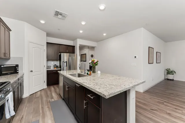 a kitchen with granite countertop kitchen island cabinets and wooden floor