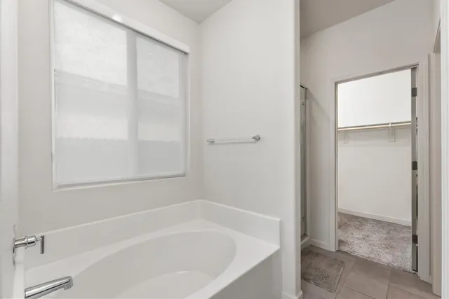 a white bath tub sitting next to a shower