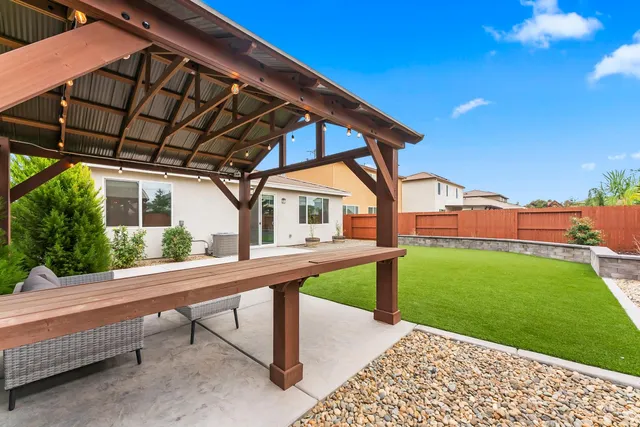 a view of a house with backyard sitting area and garden