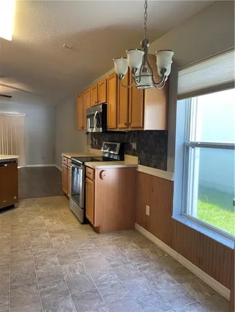 a kitchen with stainless steel appliances granite countertop a sink a stove and a window