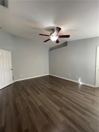 a view of a room with wooden floor and a ceiling fan