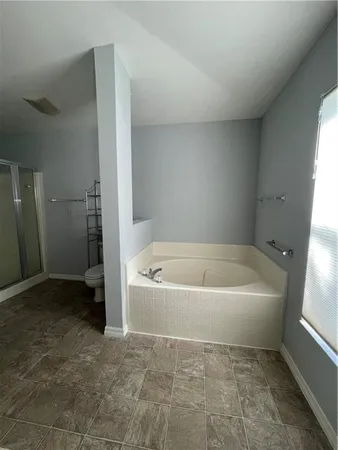 a spacious bathroom with a bathtub and a shower