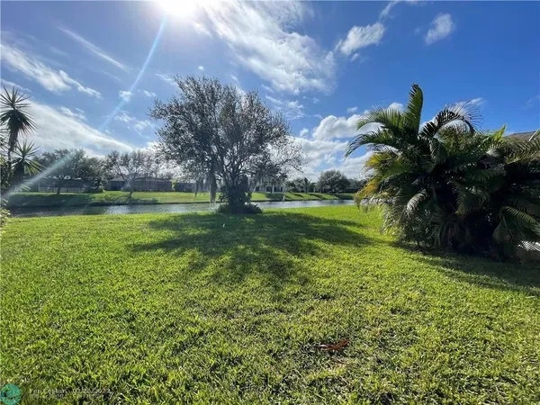 a backyard of a house with lots of green space and lake view