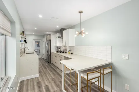 a kitchen with kitchen island a stove a refrigerator a sink dishwasher with a dining table and chairs