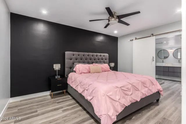a bedroom with a bed and a table with a potted plant