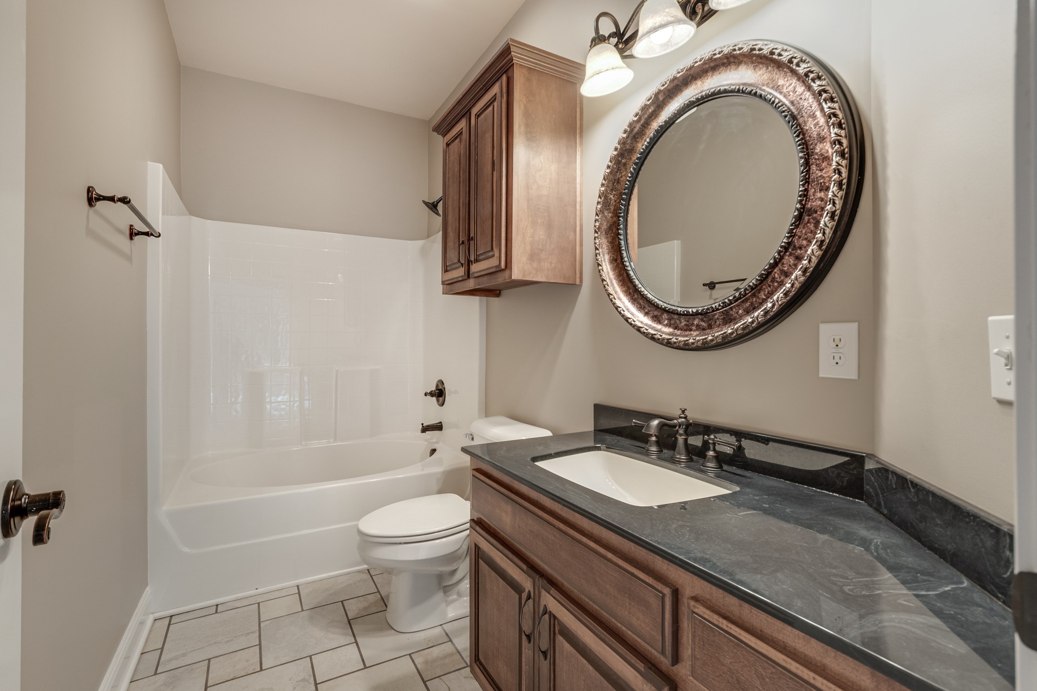 858 Coker Ford Road Portland, TN 37148 - Photo 23 of 30 a bathroom with a granite countertop toilet a sink and a mirror