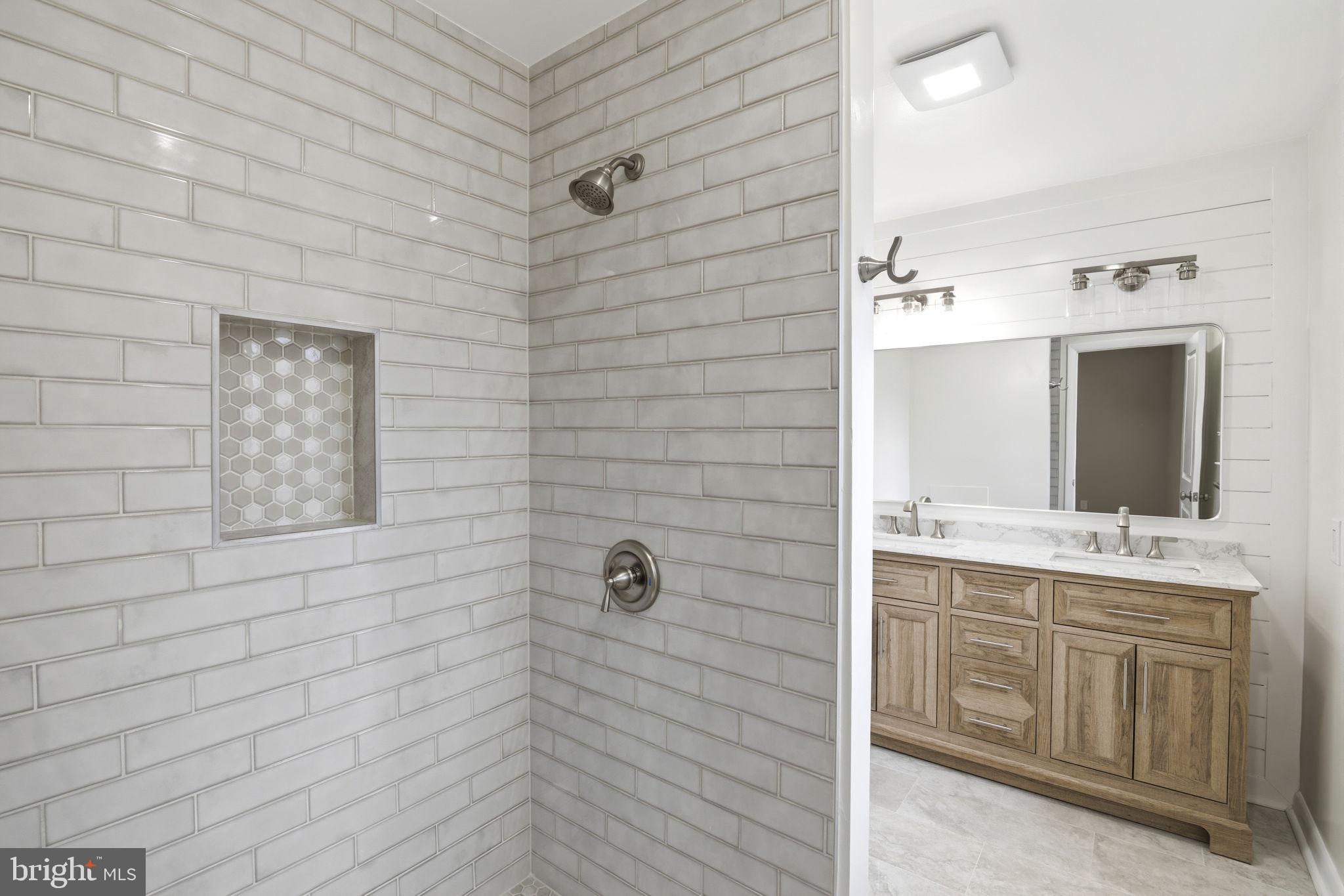 2815 Northwind Road Parkville, MD 21234 - Photo 12 of 21 a bathroom with a double vanity sink a mirror and a shower