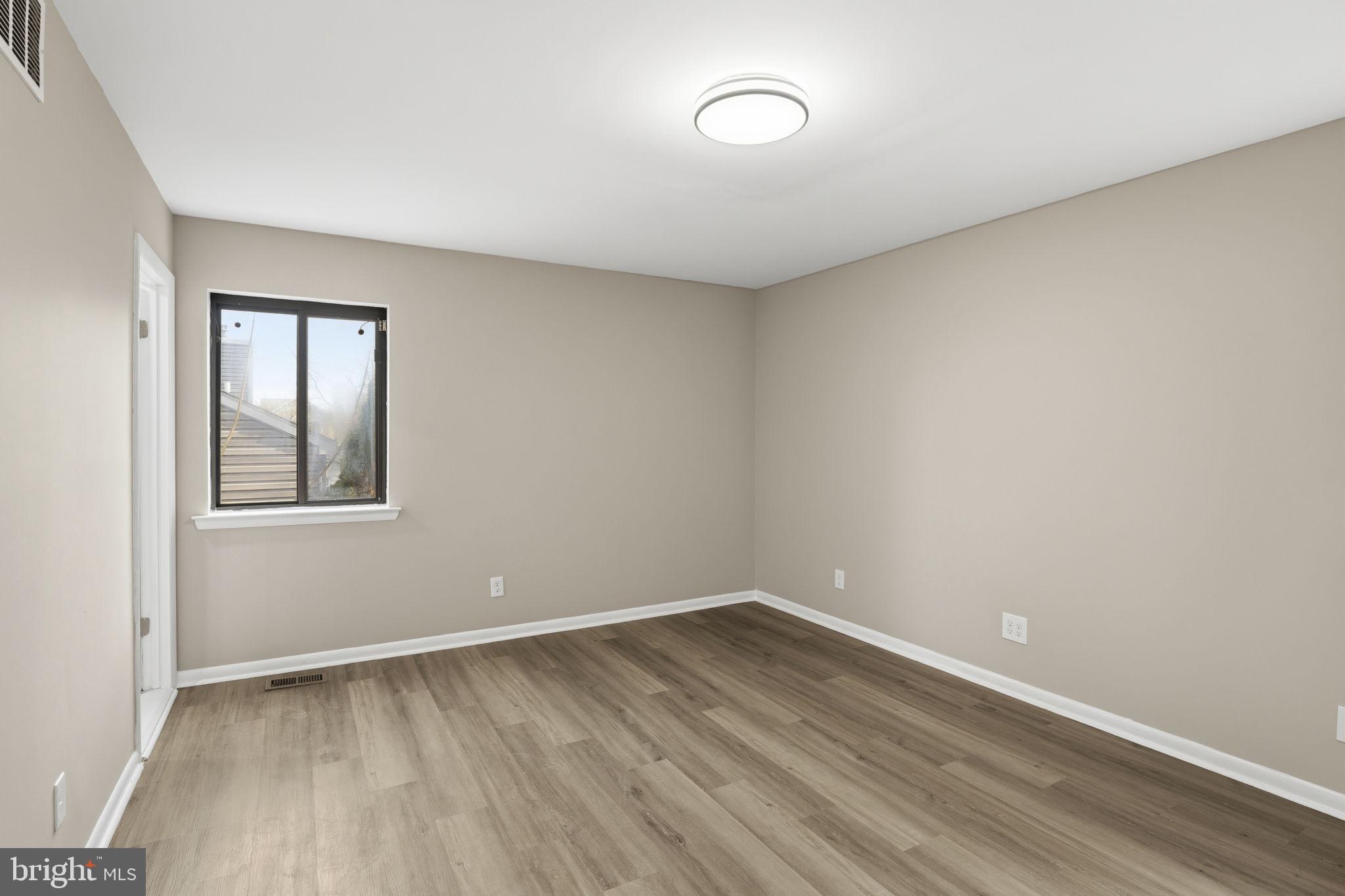 2815 Northwind Road Parkville, MD 21234 - Photo 9 of 21 wooden floor in an empty room with a window