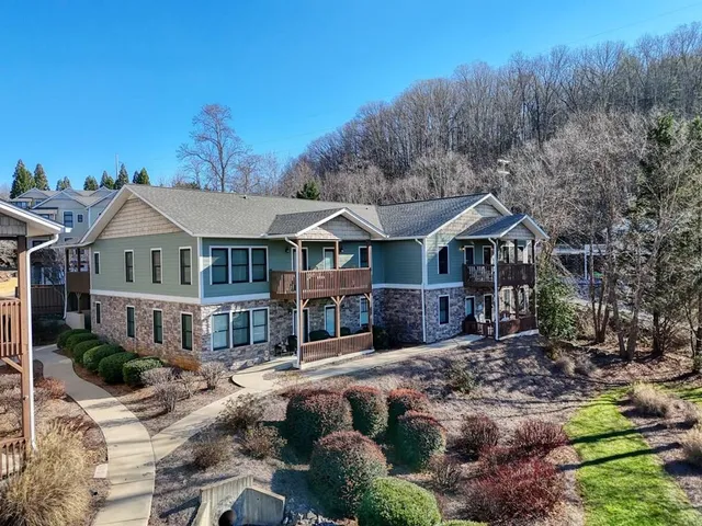 a front view of a residential houses with yard and mountain view in back