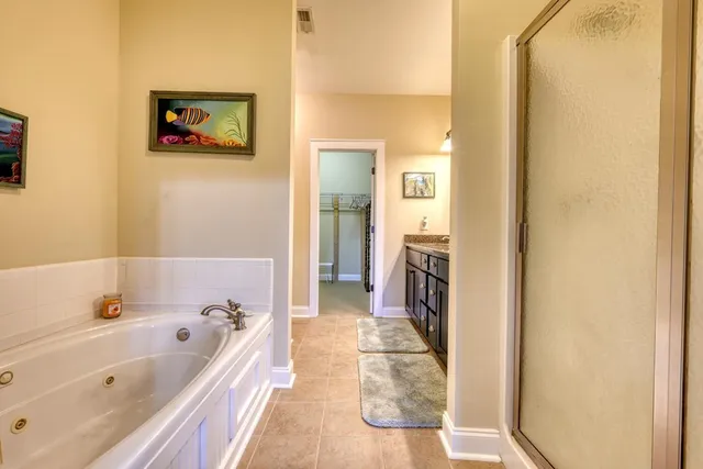 a bathroom with a tub a sink and a mirror