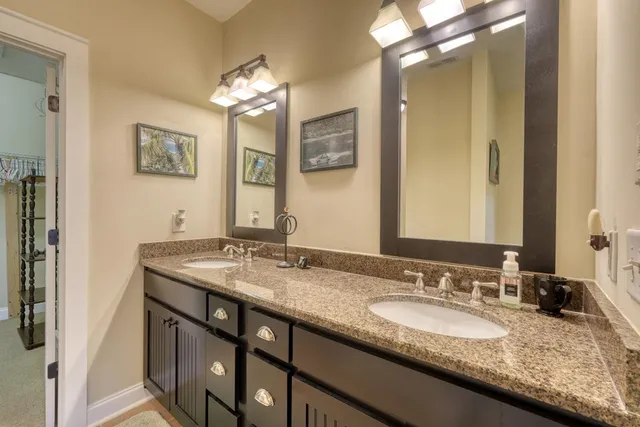 a bathroom with a granite countertop double vanity sinks and a mirror