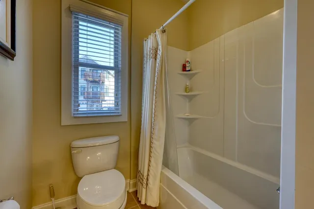a white toilet sitting next to a bath tub