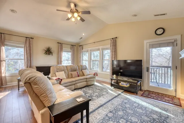a living room with furniture a flat screen tv and a window