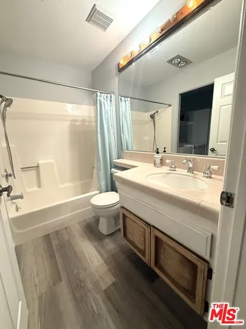 a bathroom with a granite countertop sink a toilet a mirror and vanity