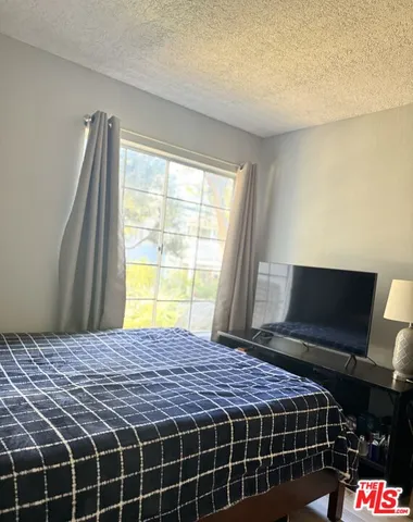 a bedroom with a bed and flat screen tv