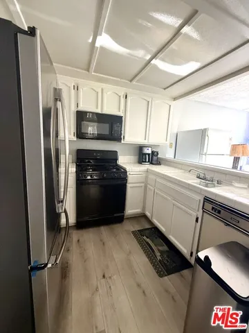 a kitchen with a refrigerator a sink a stove a microwave and cabinets