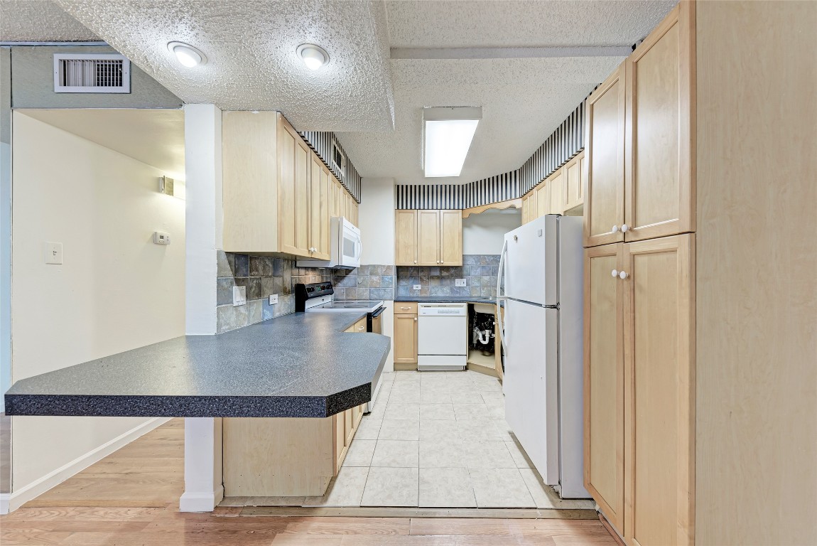 2404 Longview Street, Unit 101 Austin, TX 78705 - Photo 2 of 5 a kitchen with stainless steel appliances granite countertop a refrigerator a stove and a sink