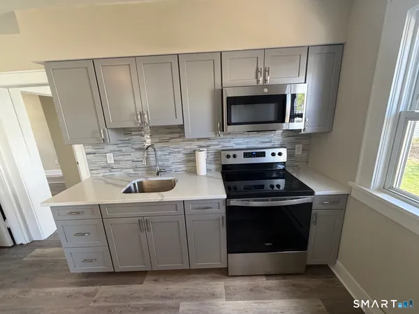 a kitchen with stainless steel appliances a stove a sink and a microwave