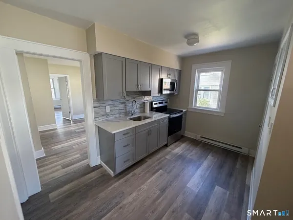 a kitchen with a refrigerator stove top oven and sink