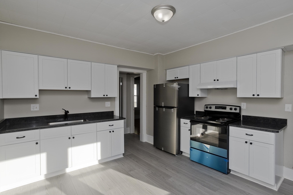 34-36 Ruskin Street Springfield, MA 01108 - Photo 13 of 27 a kitchen with granite countertop a refrigerator stove and sink
