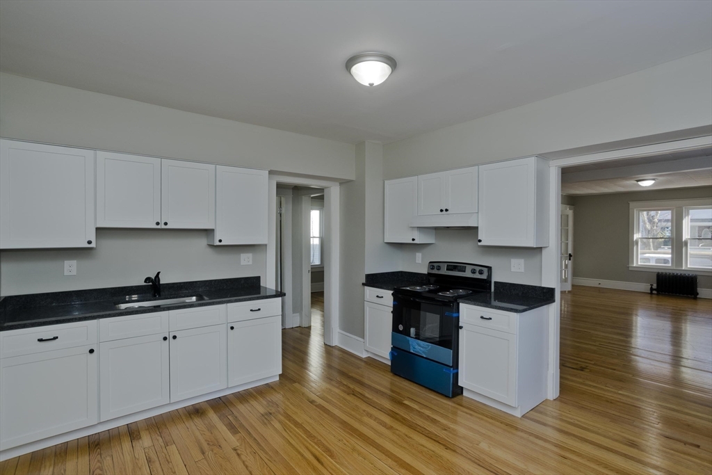 34-36 Ruskin Street Springfield, MA 01108 - Photo 5 of 27 a kitchen with stainless steel appliances granite countertop a stove top oven a sink and white cabinets