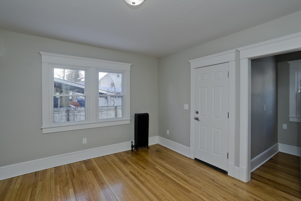 34-36 Ruskin Street Springfield, MA 01108 - Photo 7 of 27 a view of an empty room with wooden floor and a window
