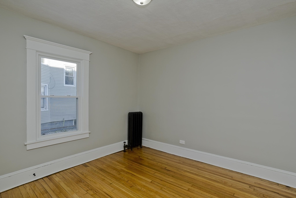 34-36 Ruskin Street Springfield, MA 01108 - Photo 9 of 27 a view of an empty room with wooden floor and a window