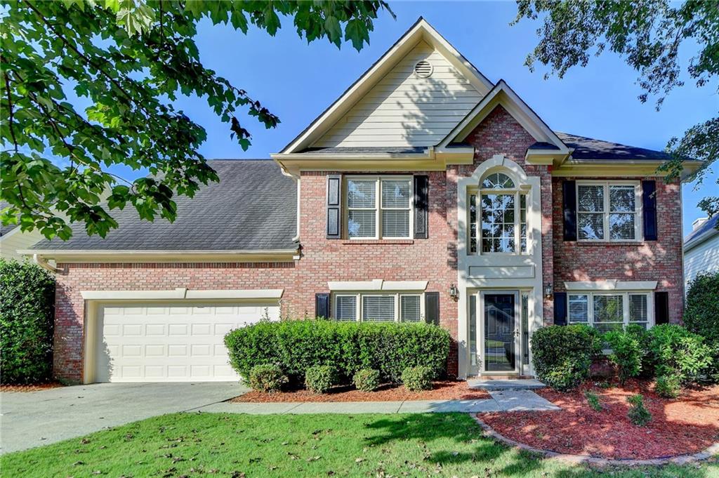 a front view of a house with a yard and potted plants