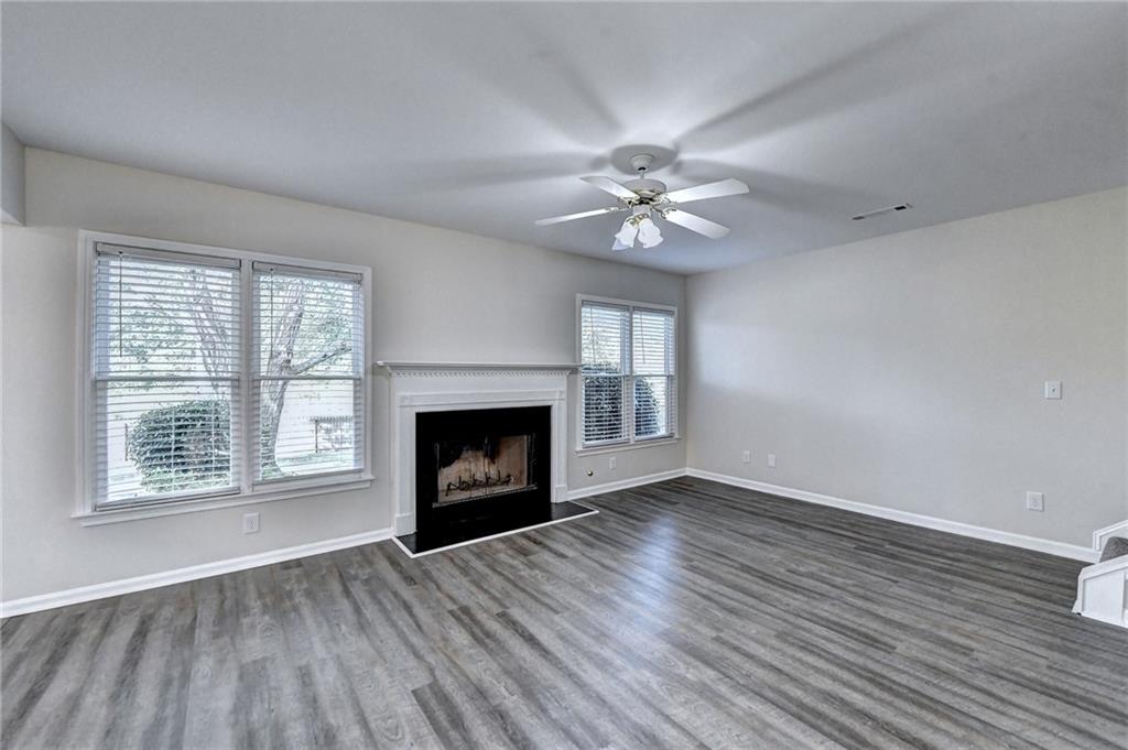 3460 Maple Terrace Drive Suwanee, GA 30024 - Photo 12 of 51 wooden floor fireplace and windows in an empty room