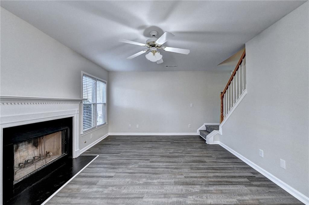 3460 Maple Terrace Drive Suwanee, GA 30024 - Photo 13 of 51 a view of an empty room with wooden floor fireplace and a window