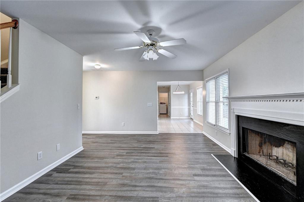 3460 Maple Terrace Drive Suwanee, GA 30024 - Photo 15 of 51 a view of an empty room with wooden floor fireplace and a window
