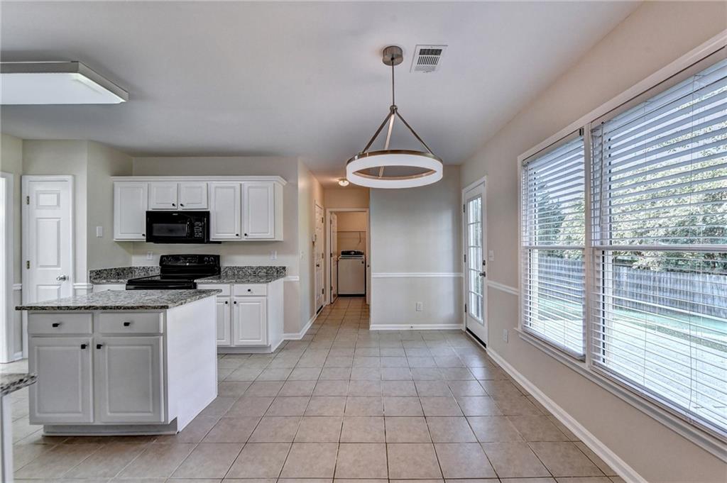 3460 Maple Terrace Drive Suwanee, GA 30024 - Photo 17 of 51 a kitchen with stainless steel appliances a sink a stove a refrigerator and cabinets