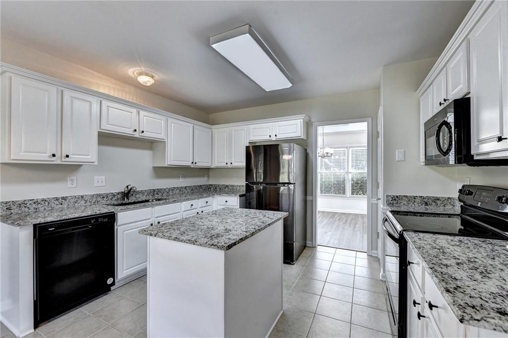 3460 Maple Terrace Drive Suwanee, GA 30024 - Photo 21 of 51 a kitchen with a stove a refrigerator and a sink