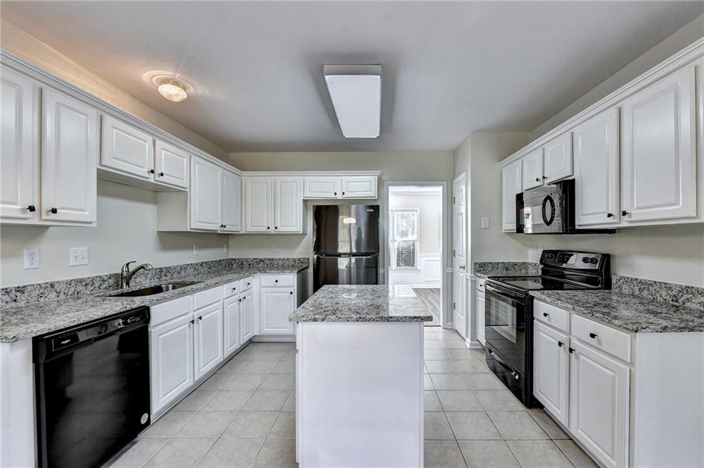 3460 Maple Terrace Drive Suwanee, GA 30024 - Photo 23 of 51 a large kitchen with stainless steel appliances granite countertop a stove sink and cabinets