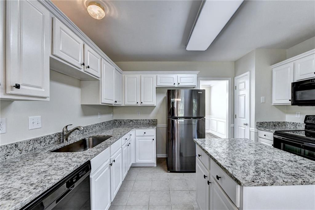 3460 Maple Terrace Drive Suwanee, GA 30024 - Photo 24 of 51 a kitchen with a sink a refrigerator and a stove top oven