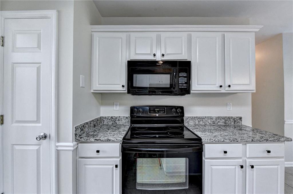 3460 Maple Terrace Drive Suwanee, GA 30024 - Photo 26 of 51 a kitchen with granite countertop white cabinets and a stove