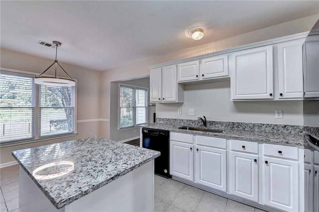 3460 Maple Terrace Drive Suwanee, GA 30024 - Photo 27 of 51 a kitchen with granite countertop a sink window and cabinets