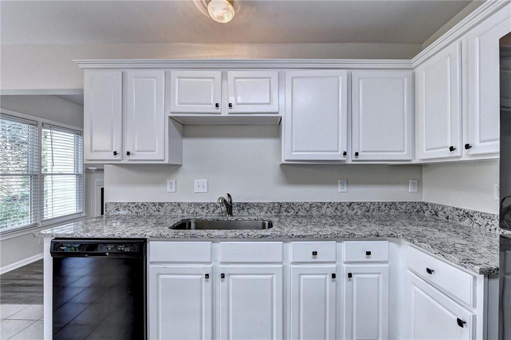 3460 Maple Terrace Drive Suwanee, GA 30024 - Photo 28 of 51 a kitchen with stainless steel appliances granite countertop white cabinets granite counter tops and a wooden floor