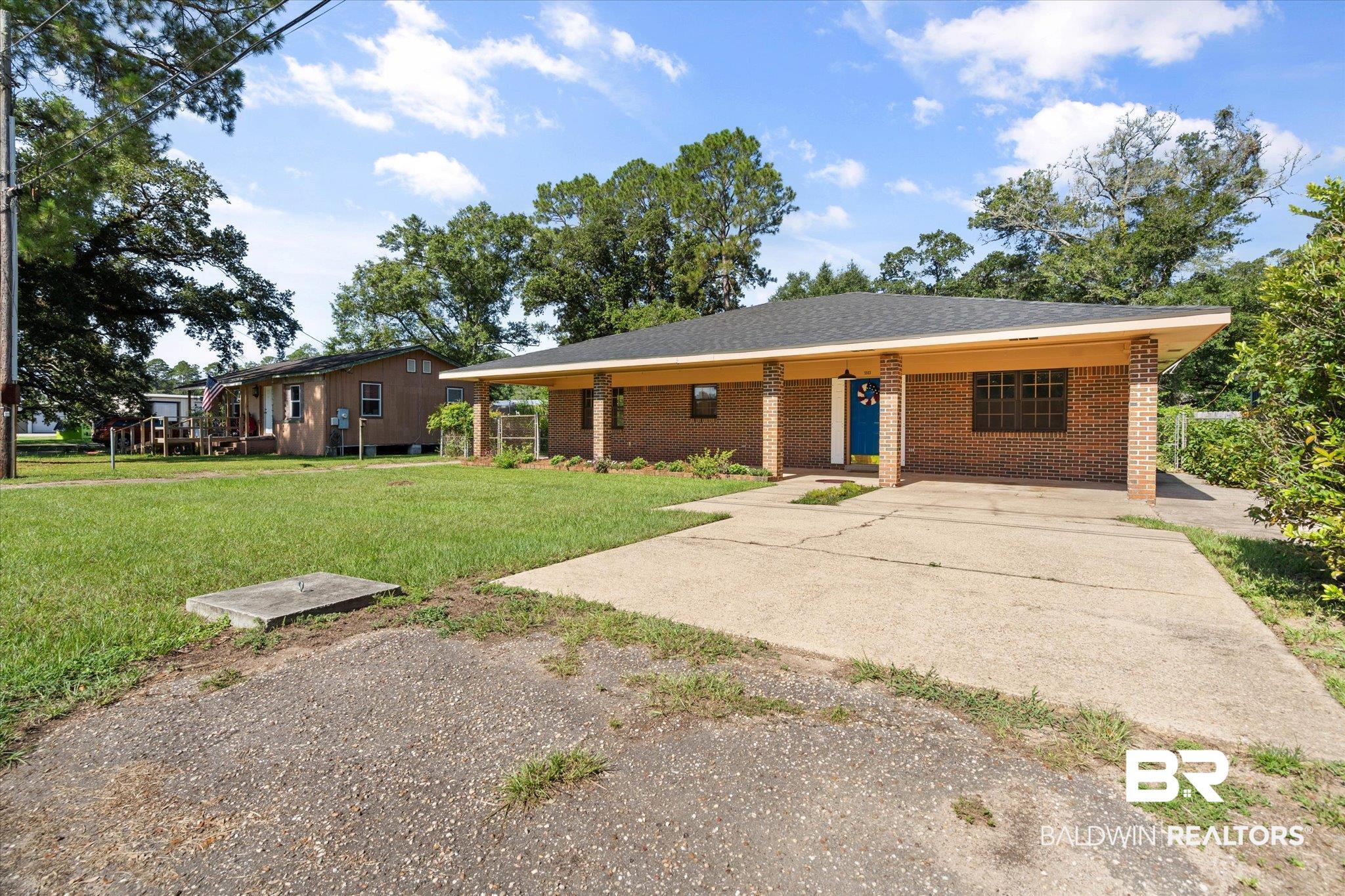 5503 Darring Street Satsuma, AL 36572 - Photo 30 of 31 View of front facade with brick siding, a front lawn, and driveway