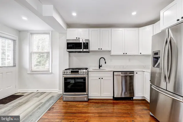 a kitchen with stainless steel appliances granite countertop a stove a sink and a refrigerator