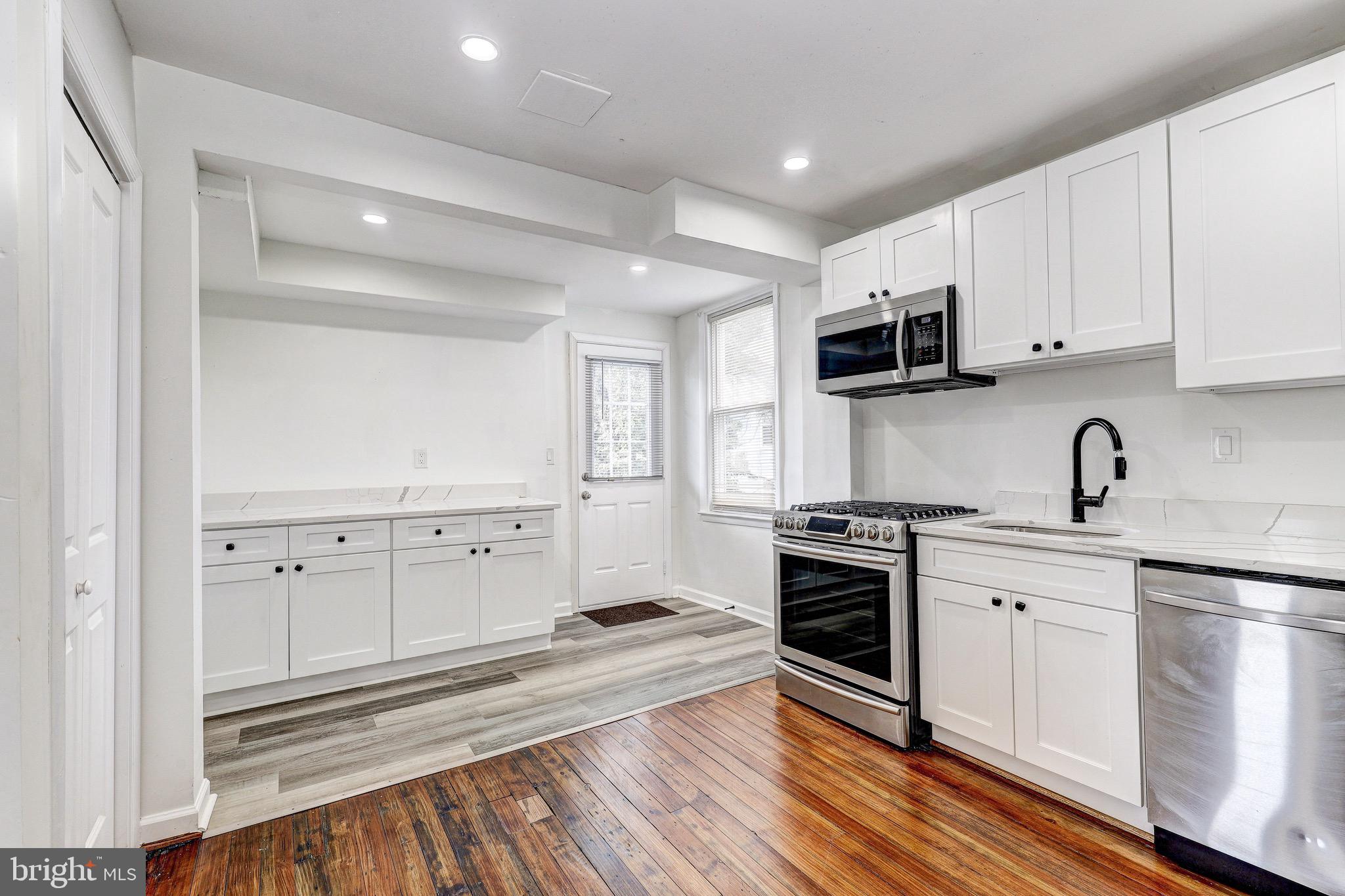 2805 Hamilton Avenue Baltimore, MD 21214 - Photo 21 of 41 a kitchen with stove cabinets and wooden floor