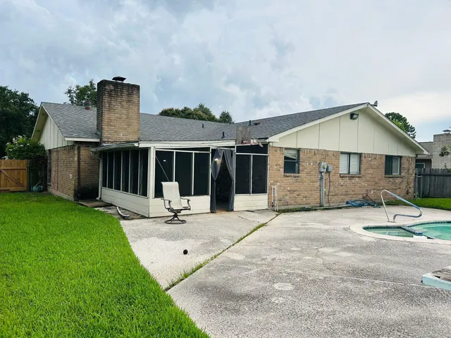 a view of a house with backyard and sitting area
