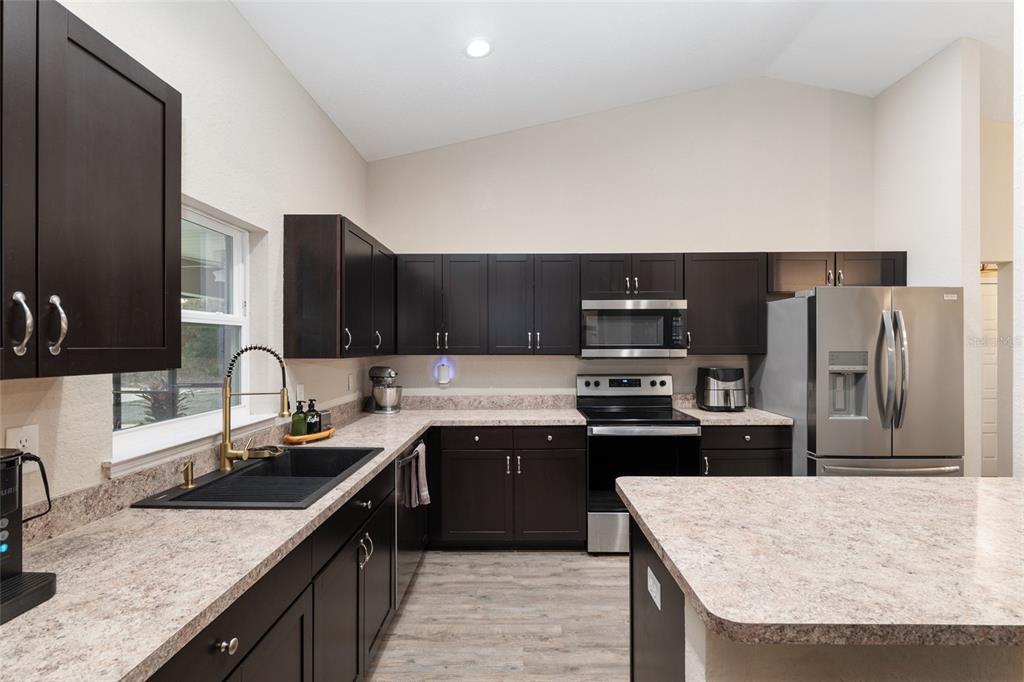 13700 Southwest 71st Lane Ocala, FL 34481 - Photo 29 of 100 a kitchen with stainless steel appliances granite countertop a sink stove and refrigerator