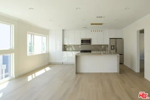 a view of a kitchen with a sink a microwave and cabinets