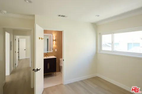 an empty room with a window and wooden floor