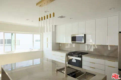 a kitchen with granite countertop a stove and a sink